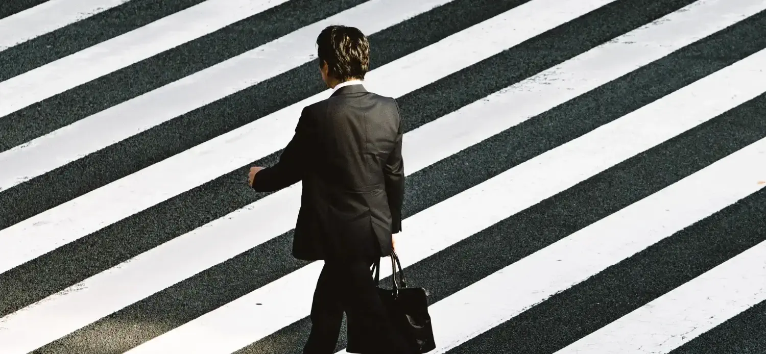 Homme d'affaires marchant sur un passage piéton.